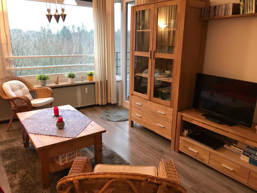 a living room with a television and a table and chairs at Ferienappartement Peters in Glücksburg