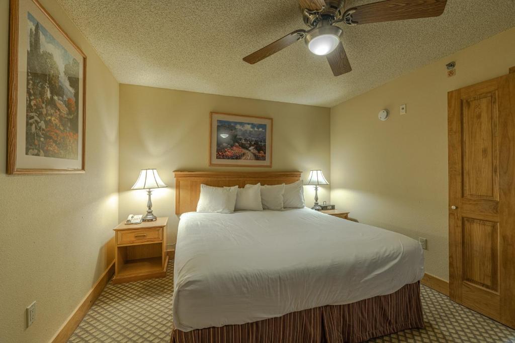 a bedroom with a large bed and two night stands with lamps at Grand Lodge Condo in the Heart of Mt Crested Butte condo in Crested Butte