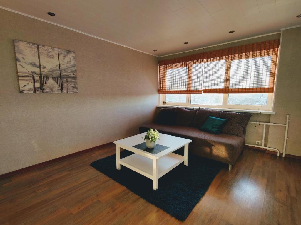 uma sala de estar com um sofá e uma mesa em Kotkapesa Apartment em Kiviõli