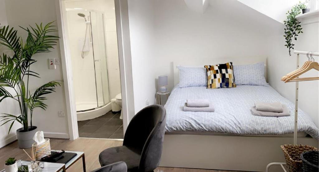 a bedroom with a bed, chair, desk and a lamp at Citywide ApartHotel in Liverpool