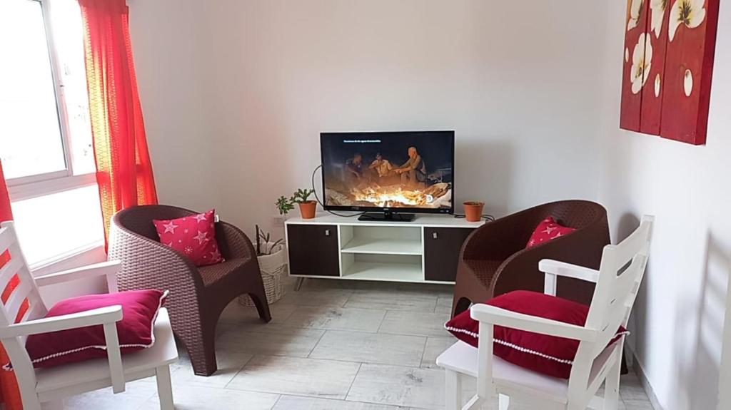Una sala de estar con dos sillas y un televisor. en A metros de la Playa...., en Federación