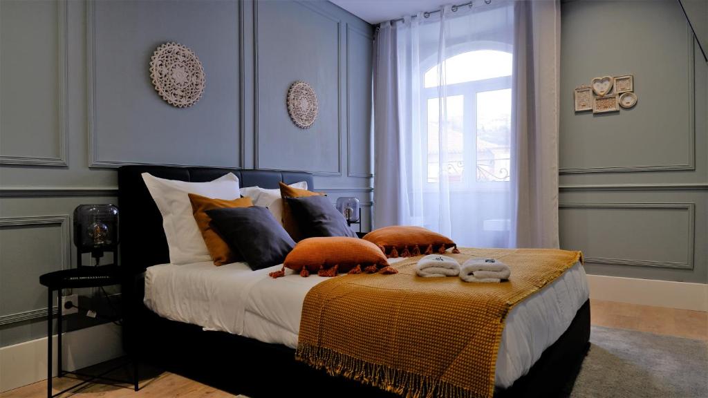 a bedroom with a bed with pillows and a window at O Cantinho do Colégio - Dourocollege in Lamego