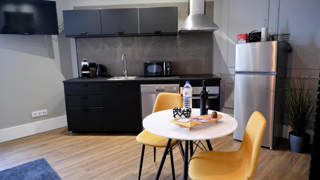 a kitchen with a table and chairs and a refrigerator at O Cantinho do Colégio - Dourocollege in Lamego