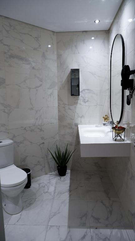 a white bathroom with a sink and a toilet at O Cantinho do Colégio - Dourocollege in Lamego