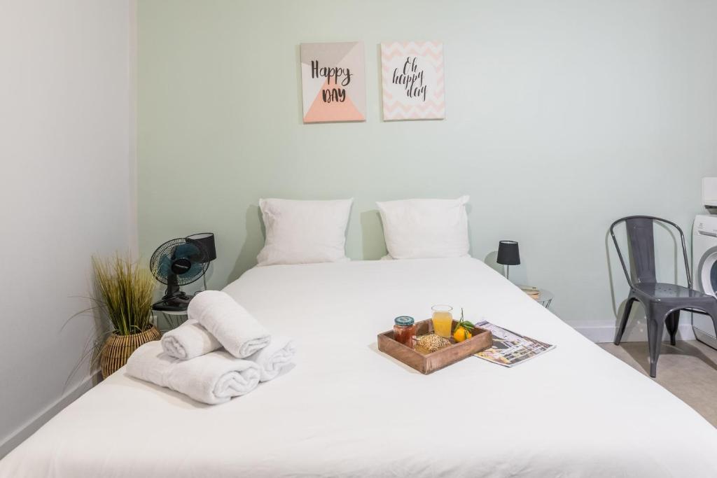 - un lit blanc avec des serviettes et une corbeille de fruits dans l'établissement Apartments WS Louvre - Saint Honoré, à Paris