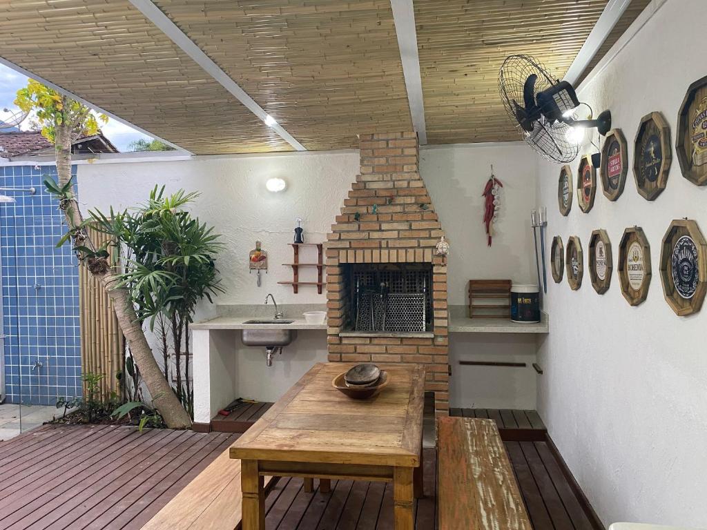 un patio con mesa de madera y chimenea en Juquehy Casa para Famílias em condomínio en Juquei