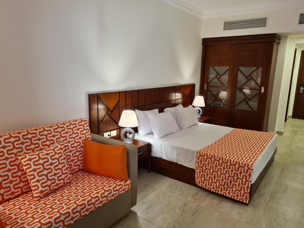 a hotel room with a bed and a couch at Oyster Bay Marsa Alam ( Unit I5-06) in Abu Dabbab