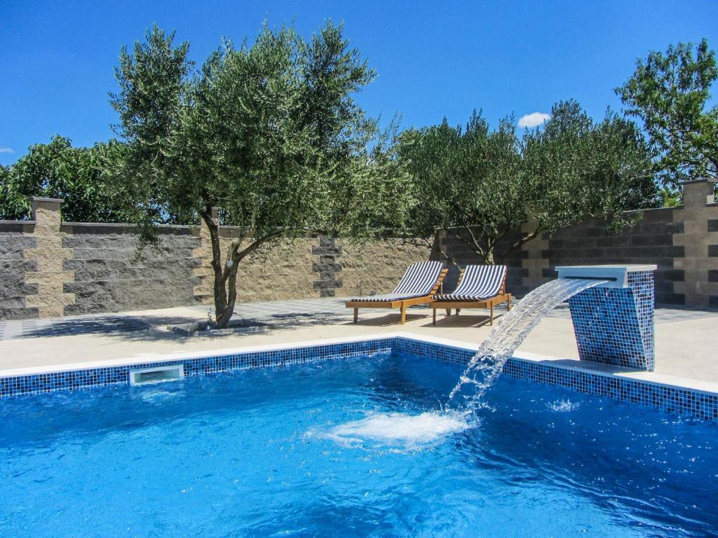 ein Swimmingpool mit Wasserfontäne in der Unterkunft Apartments Svarog in Biograd na Moru
