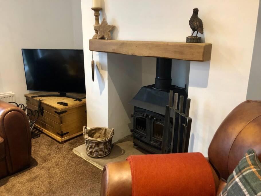 a living room with a fireplace and a television at ValleyView Cottage-Cosy, Rustic Home - Log Burner in Ushaw Moor