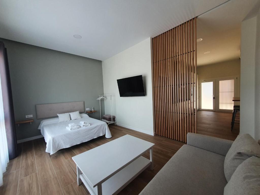 uma sala de estar com uma cama e um sofá em REDONDELA APARTMENTS - Bedroom, Bathroom & Kitchen em Redondela