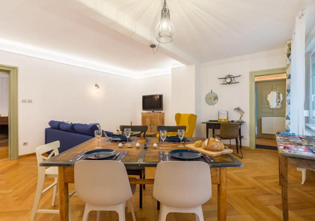 un salon avec une table et des chaises de salle à manger dans l'établissement Thann Colmar - 1 chambre - 5 pers - Parking, à Colmar