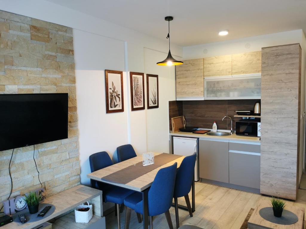 a kitchen and dining room with a table and chairs at SkyKop Apartman L21 in Kopaonik