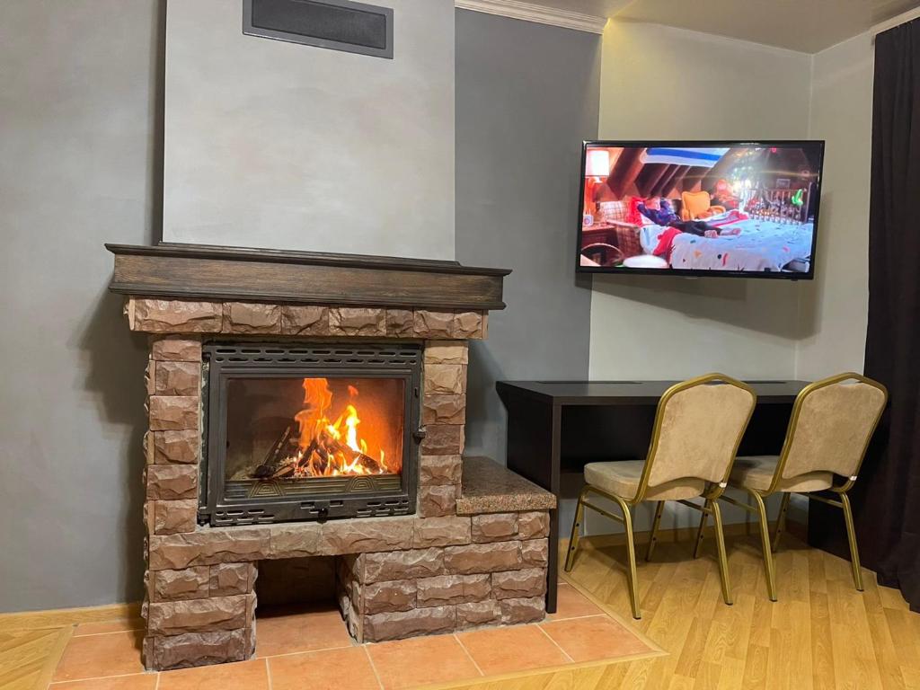 sala de estar con chimenea y TV en LIKE HOTEL en Kolomiya