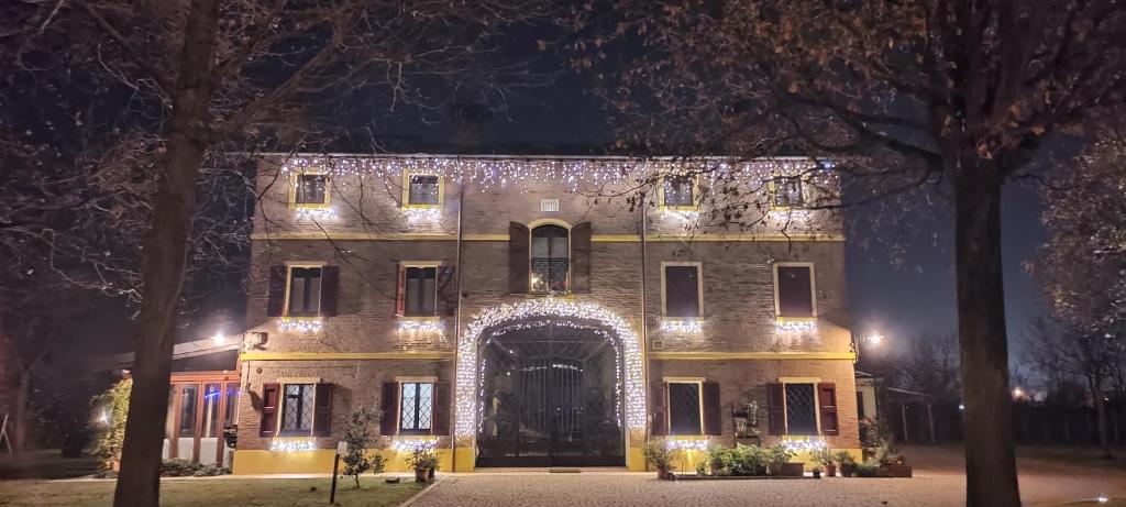 un grande edificio con un ingresso ad arco di notte di B&B Le Noci di Feo a Modena