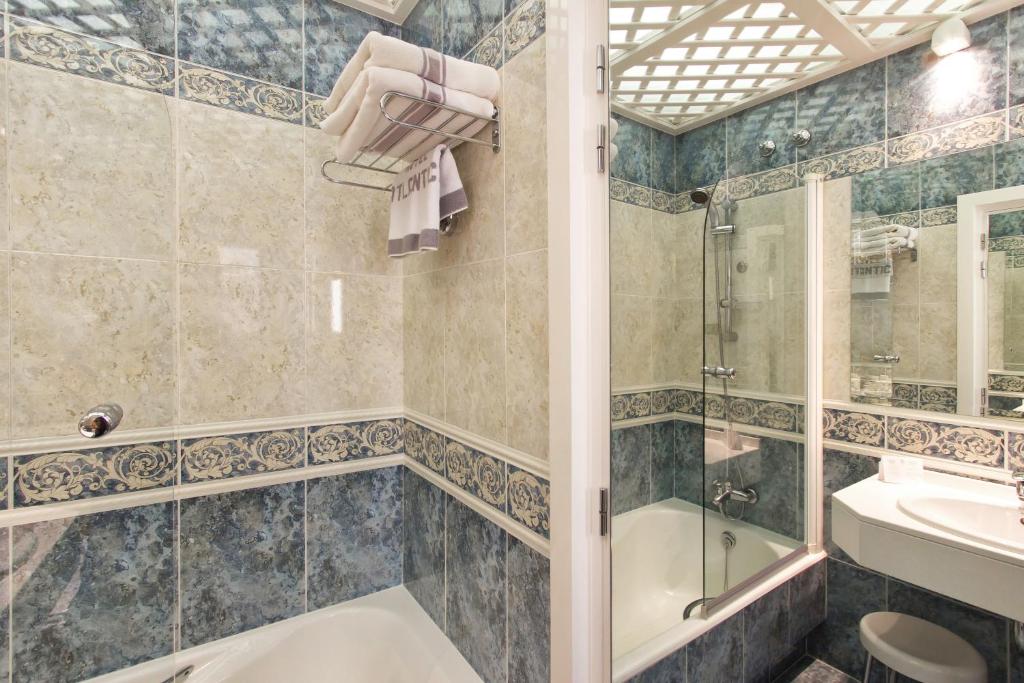 a bathroom with a shower and a tub and a sink at Hotel Atlántico in Madrid
