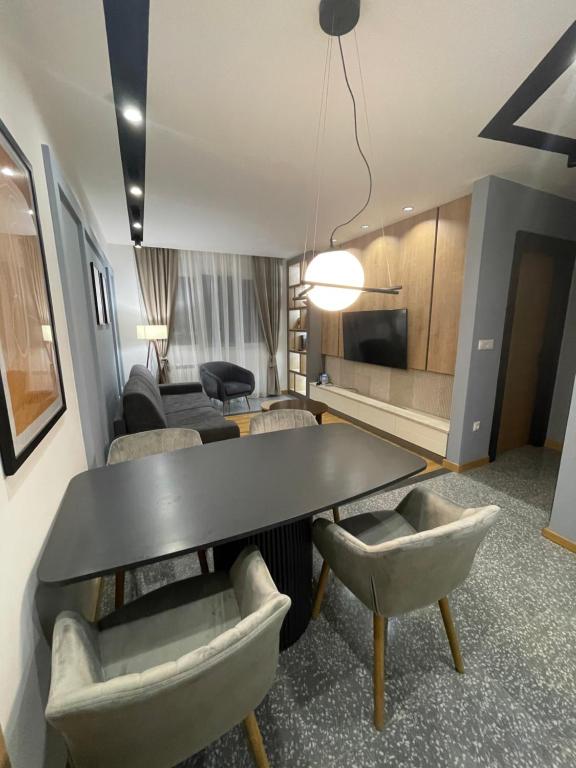 un salon avec une table et des chaises noires dans l'établissement Modern Mountain Kolasin, à Kolašin