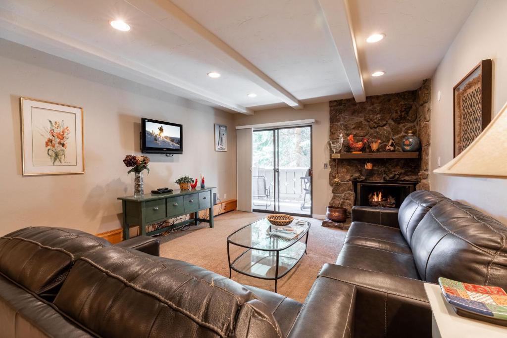a living room with a leather couch and a fireplace at Villa Cortina by Vail Realty in Vail