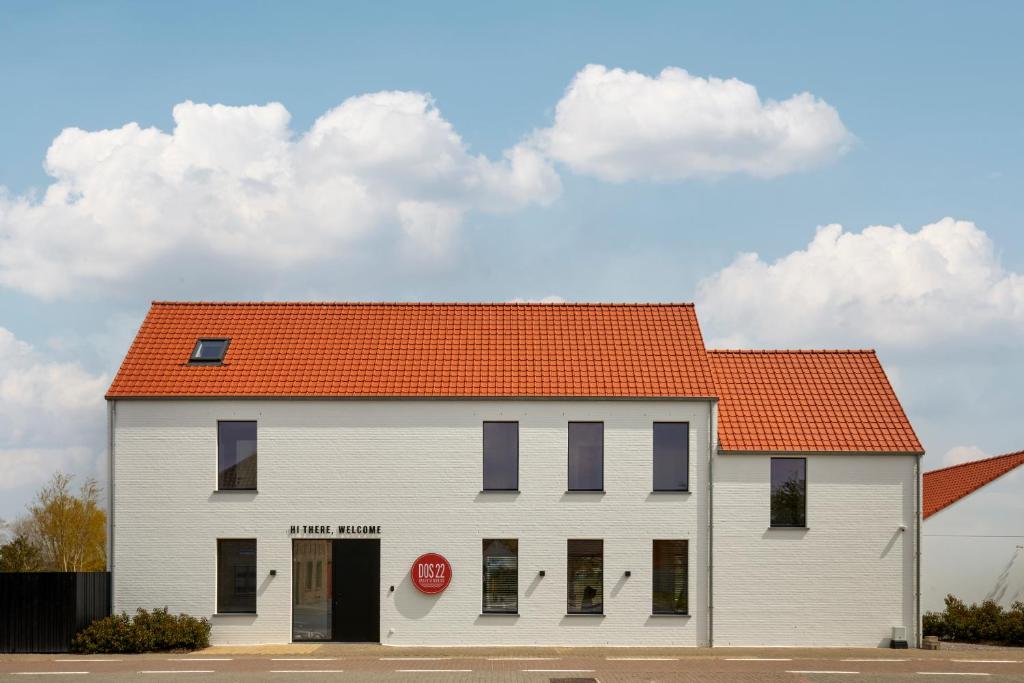 um edifício branco com um telhado laranja em DOS22 Vakantiewoning I De Haan Wenduine em Zuienkerke