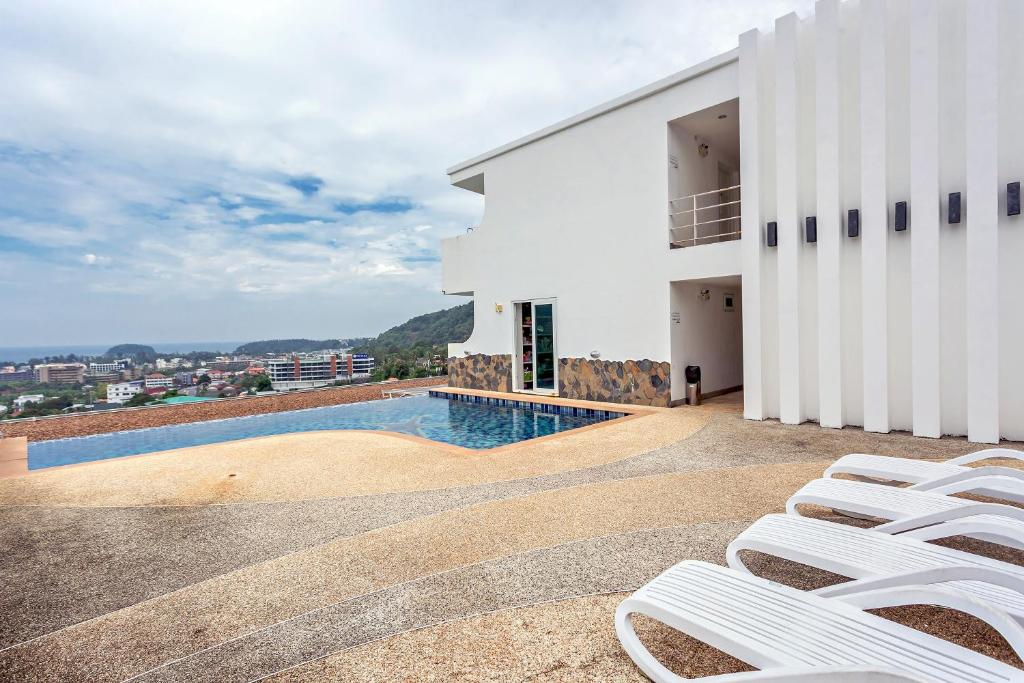 a view of a building with chairs and a swimming pool at Kata Ocean View condominium by Lofty in Kata Beach