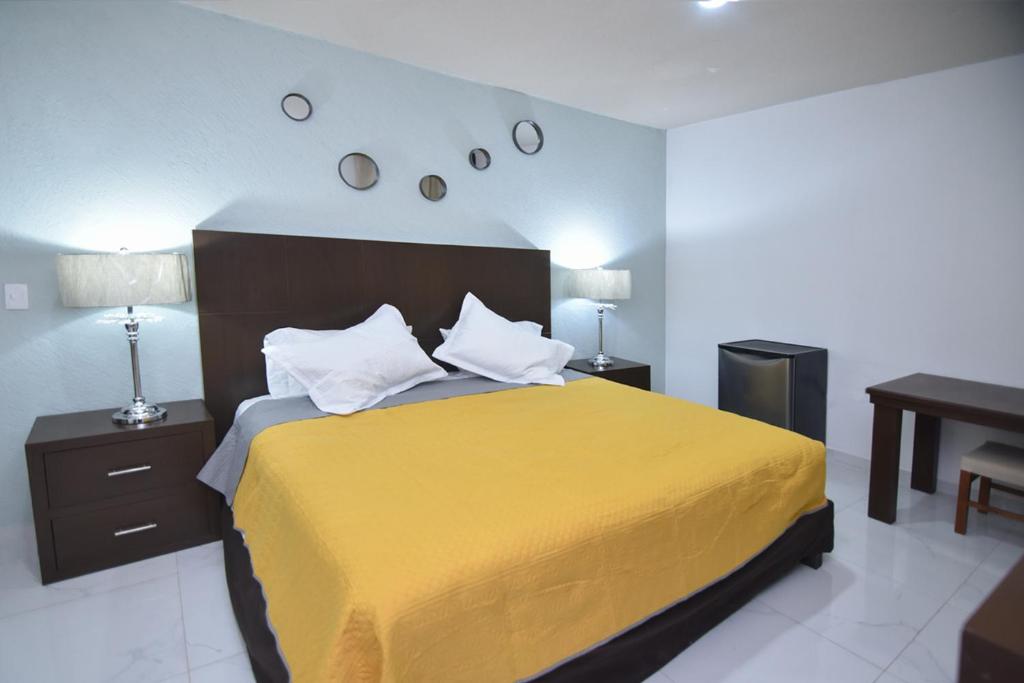 - une chambre avec un lit jaune, 2 tables de chevet et un bureau dans l'établissement HOTEL MI HERMOSO DOLORES, à Dolores Hidalgo