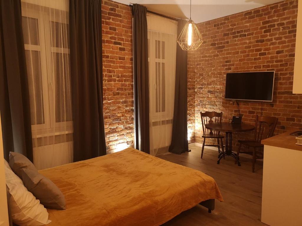 ein Schlafzimmer mit einem Bett und einer Ziegelwand in der Unterkunft Solaris Apartments Self-Check-In in Oppeln