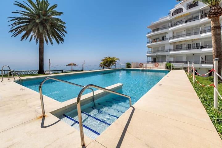 einem Pool vor einem großen Gebäude in der Unterkunft Perfect Family Apartment in Acapulco Playa, Nerja in Nerja