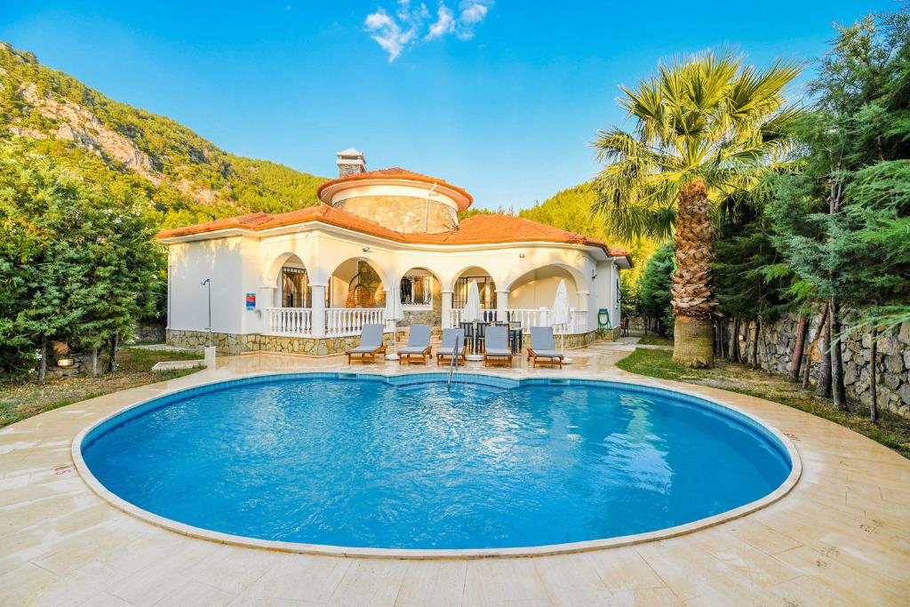 a house with a swimming pool in front of a house at Villa Tophill in Dalaman