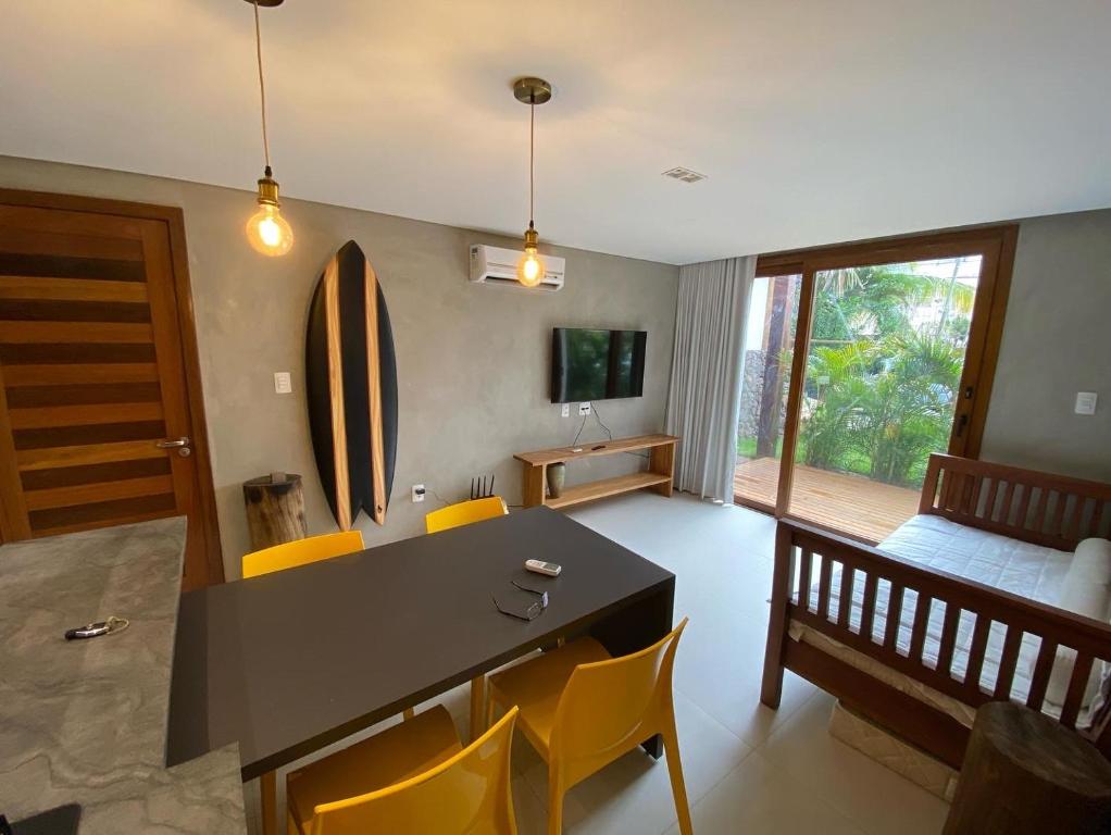 a living room with a table and chairs and a bed at Praia do Forte Ohana Residence in Praia do Forte