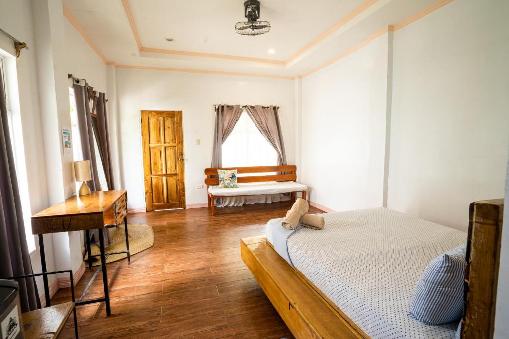 a bedroom with a bed and a table and a window at YAMA APARTMENTS - Private Beachfront in General Luna