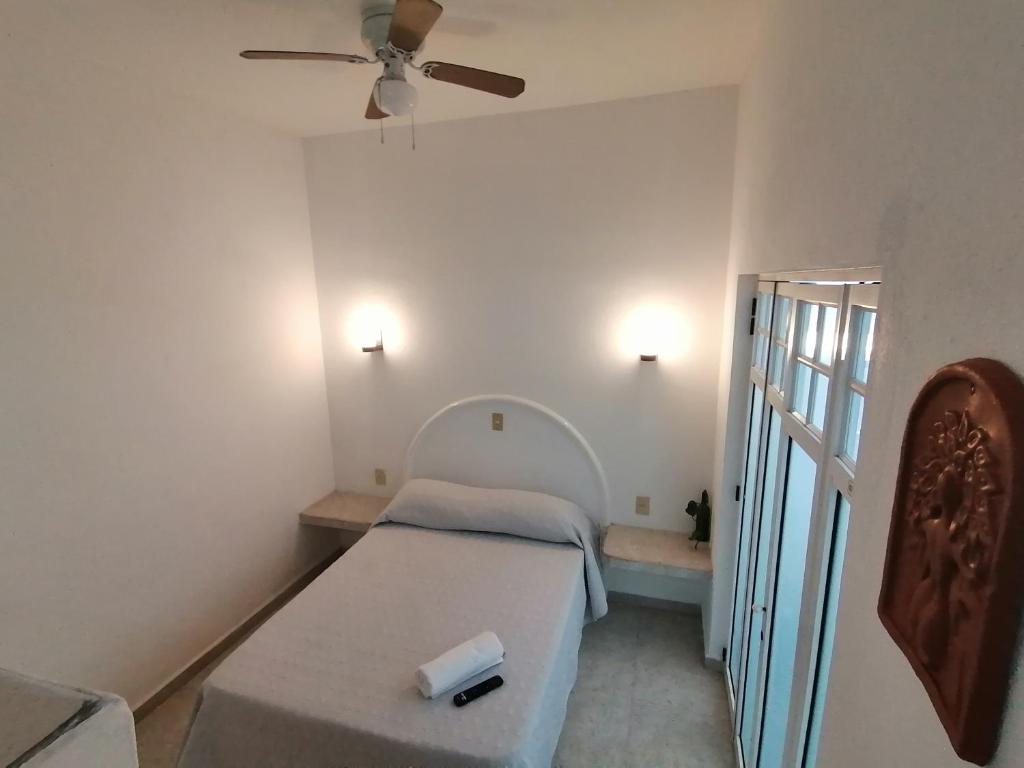 1 dormitorio pequeño con 1 cama y ventilador de techo en Htl & Suites Neruda, ubicación, limpieza, facturamos, en Colima