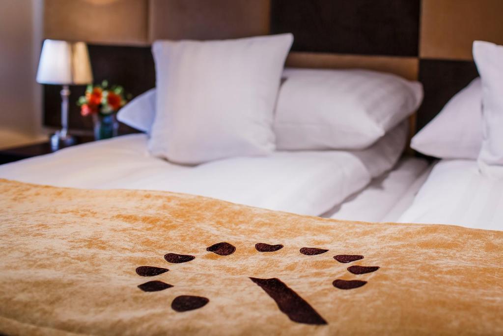 a bed with a blanket with a dog paw print at Boutique Hotel's II in Łódź