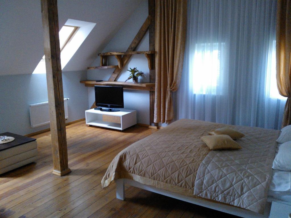 a bedroom with a bed and a television in it at Miško Apartments in Šilutė