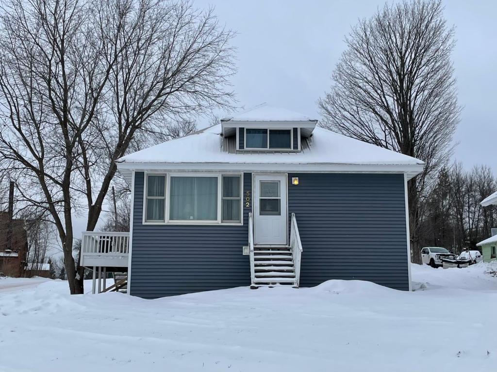 a small blue house with snow on top of it at The Blue House in Ironwood