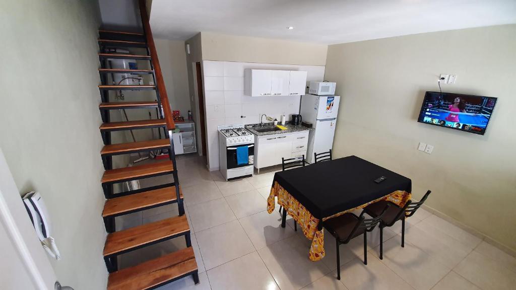 eine Küche mit einem Tisch und Stühlen sowie eine Küche mit einer Treppe in der Unterkunft Dptos CerBo in Deán Funes