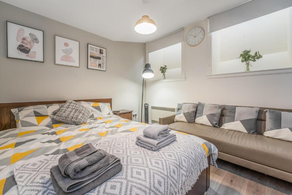 a bedroom with a bed and a couch at Relaxing & Cozy Studio Apartment - Oasis in the Heart of Edinburgh - Sleeps Up to 3 Guests in Edinburgh
