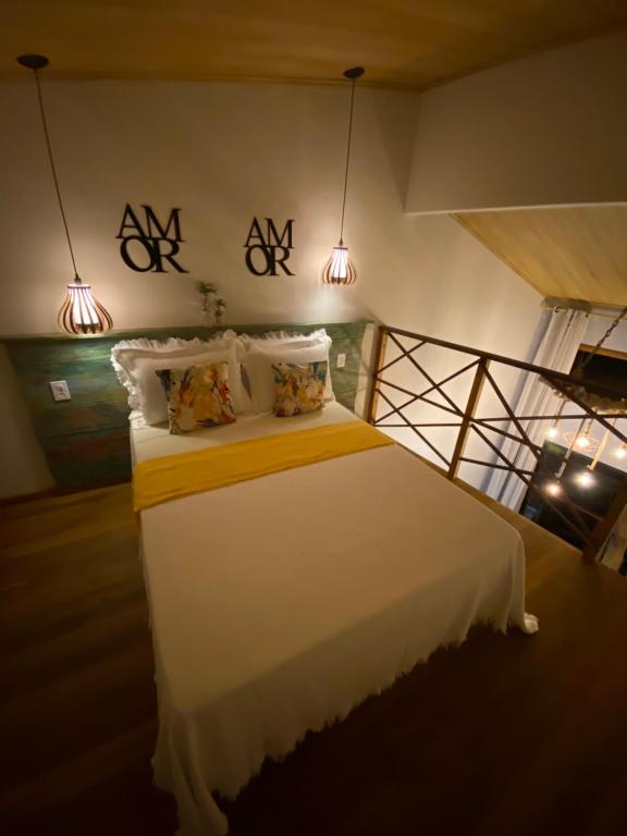 1 dormitorio con 1 cama blanca grande y 2 luces en Casa aluguel Abraão, Vista Mar en Ilha Grande