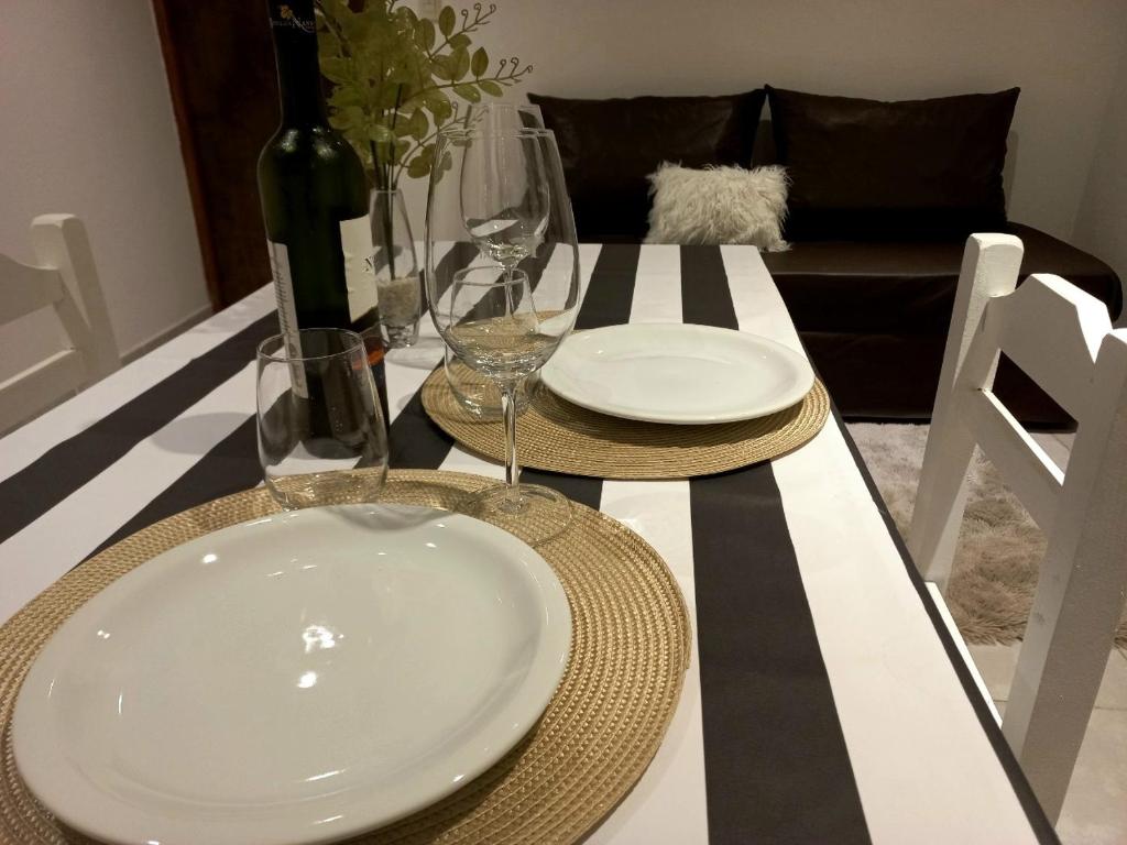 a dining room table with a white plate and wine glasses at Ayres del Rio in Formosa