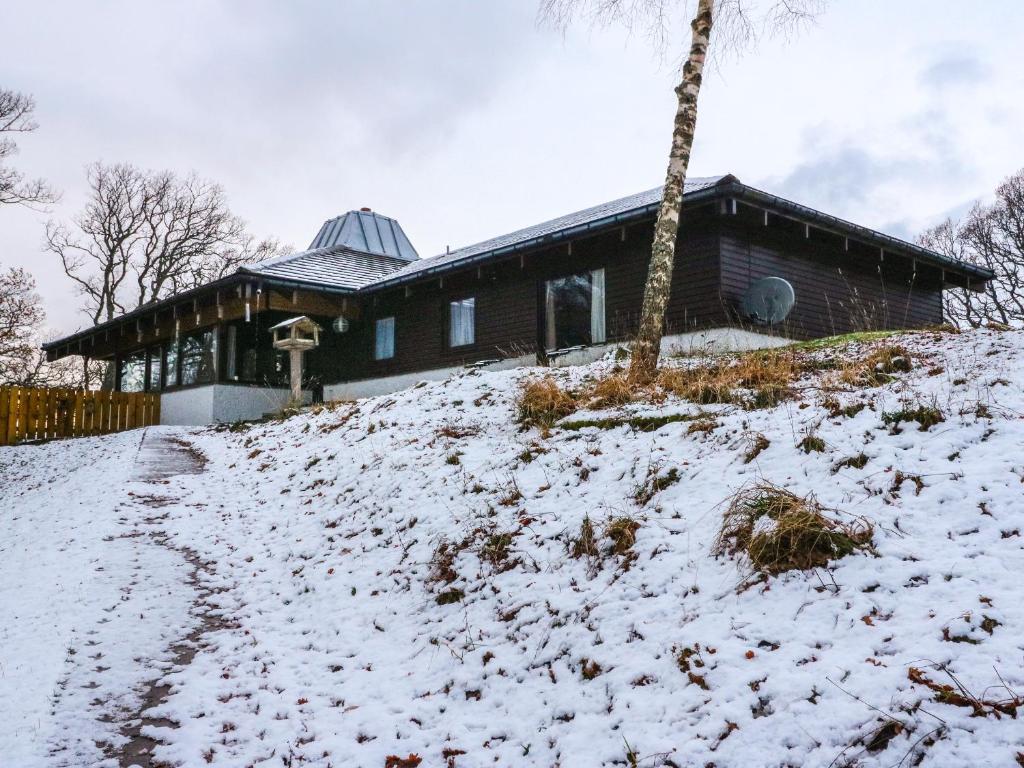 a house on top of a snow covered hill at Katchana in Insh