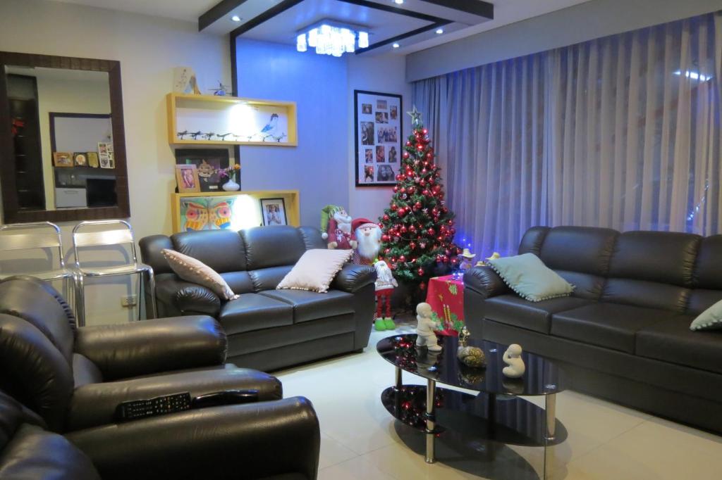 a living room with a christmas tree and leather couches at My Sweet House in Arequipa