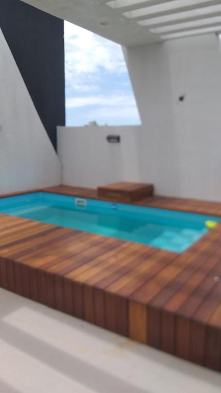 a swimming pool in a room with a wooden floor at DEPARTAMENTO TEMPORARIO ZONA PARQUE in Paraná