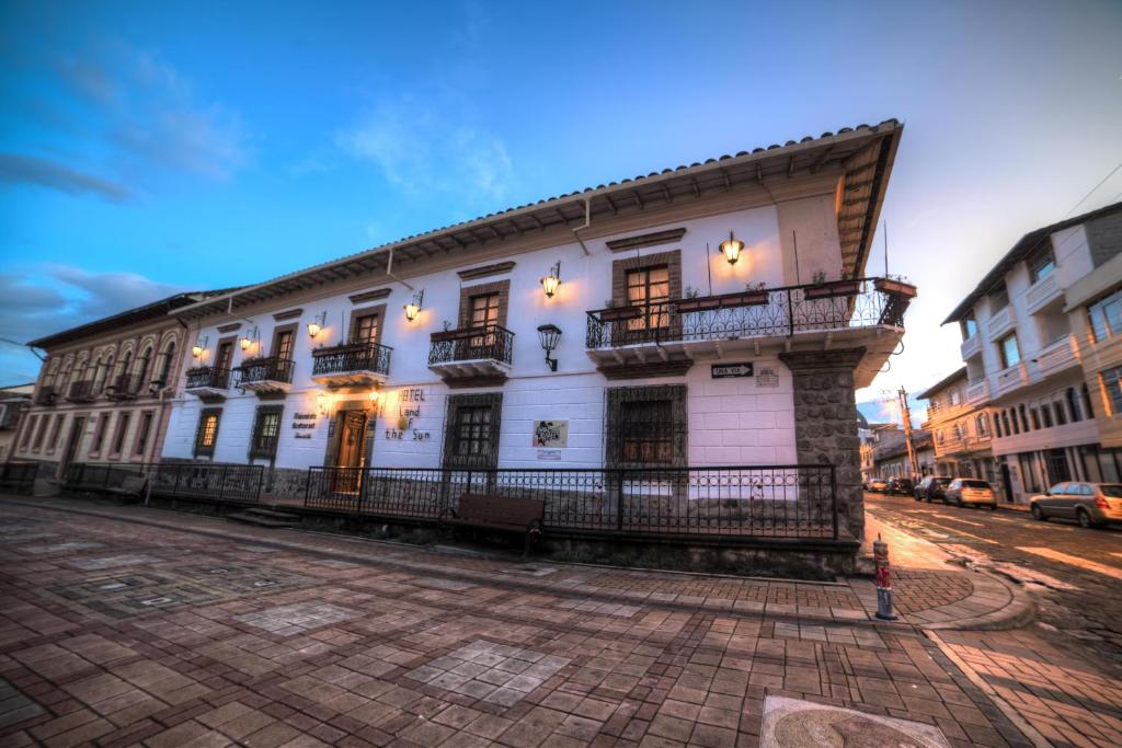 un edificio blanco con balcones en una calle de la ciudad en Land of the Sun Hotel & Spa, en Cotacachi