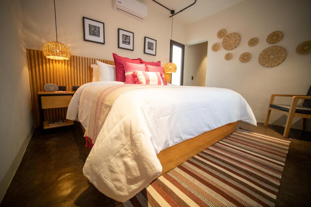 a bedroom with a large bed with red pillows at Casa Rosamate in Oaxaca City