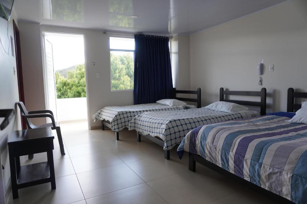 - une chambre avec 2 lits et une grande fenêtre dans l'établissement Hotel Alta Vista Campestre, à Tibasosa