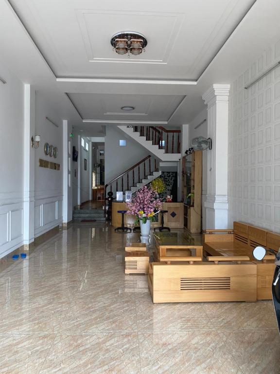 a living room with wooden floors and a staircase at Melody Homestay Quy Nhơn in Quy Nhon