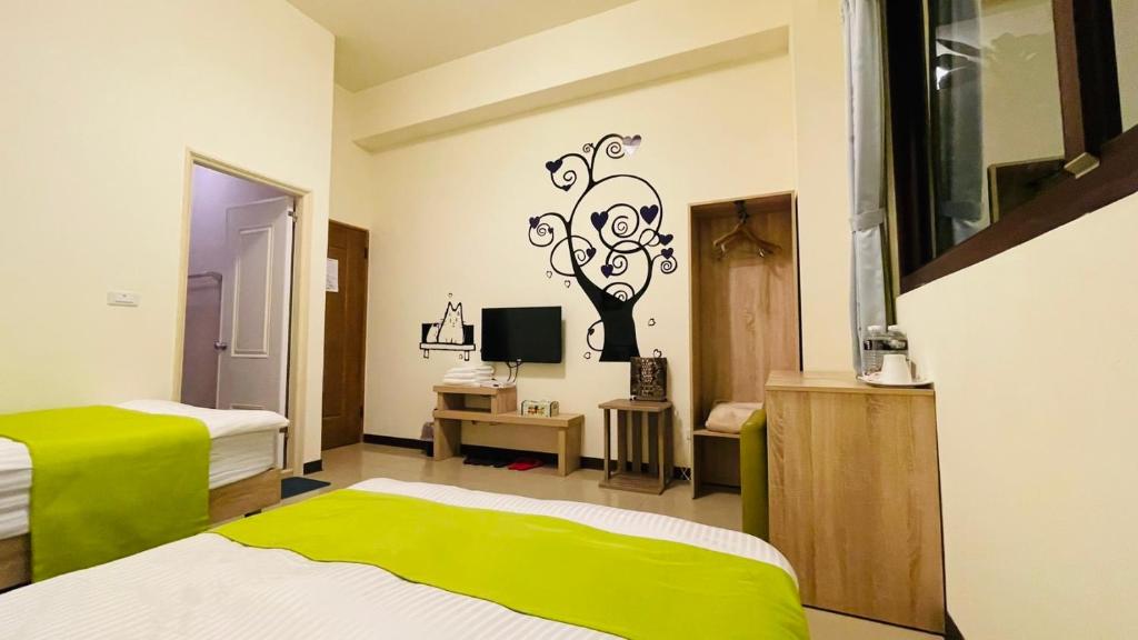 a bedroom with two beds and a tv in it at 八八小屋心享民宿 in Jinning