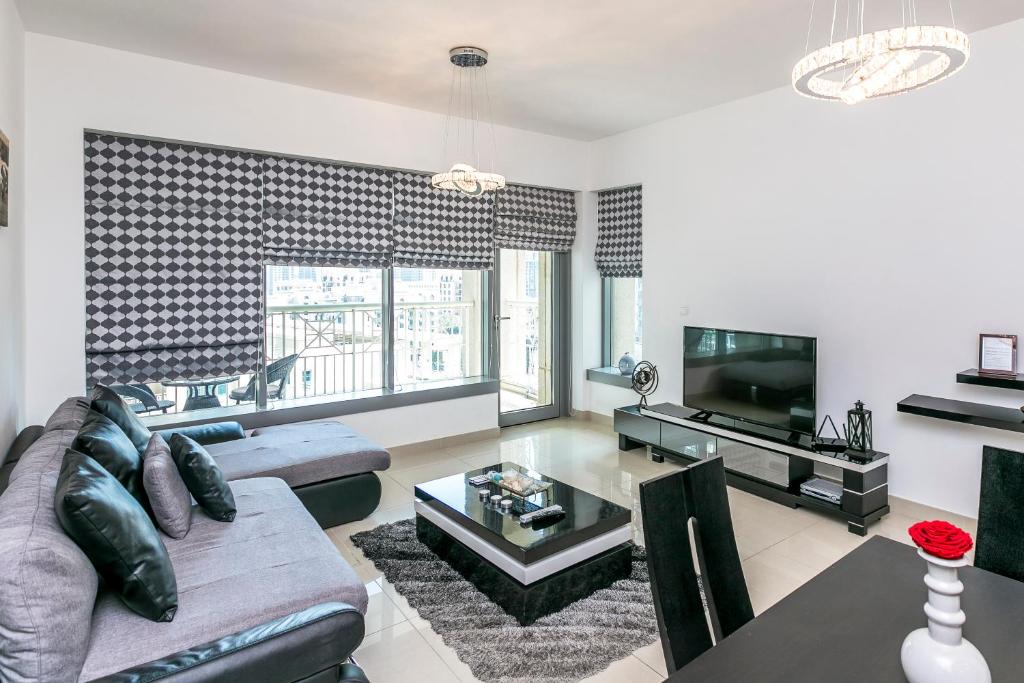 a living room with a couch and a tv at 1BR Boulevard View 29 Blvd T2 Downtown in Dubai