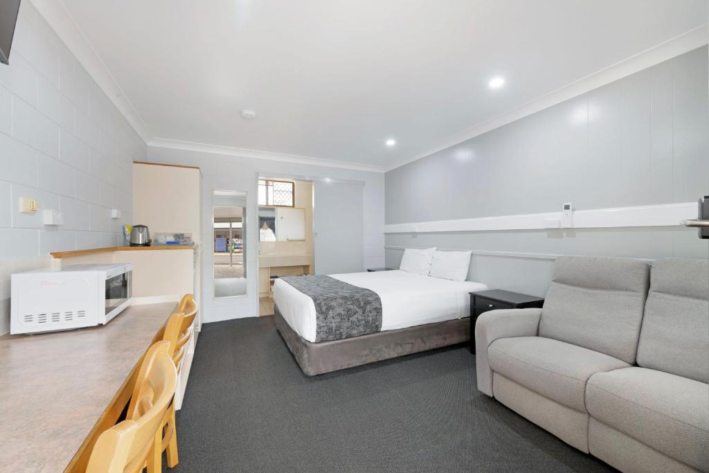 pokój hotelowy z łóżkiem i kanapą w obiekcie Best Western Bundaberg City Motor Inn w mieście Bundaberg