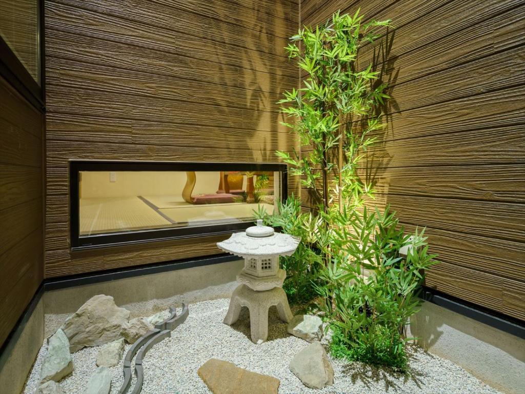 een Japanse tuin met een stenen tafel en een boom bij YADOYA Ryusenjicho in Tokyo