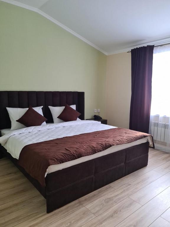 a bedroom with a large bed in a room at Гостиничный комплекс Адал in Shchūchīnsk