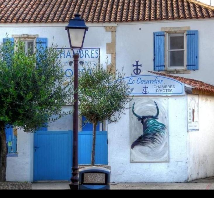 a street light in front of a building with a sign at Le Cocardier in Saintes-Maries-de-la-Mer